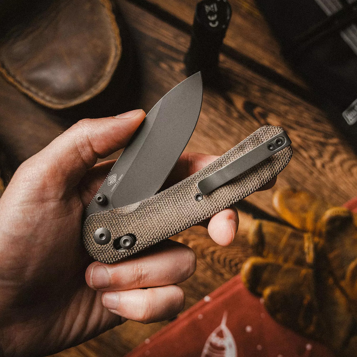 Lander 2 Pocket Knife in Moondust Micarta, closed, held in hand against autumn leaves