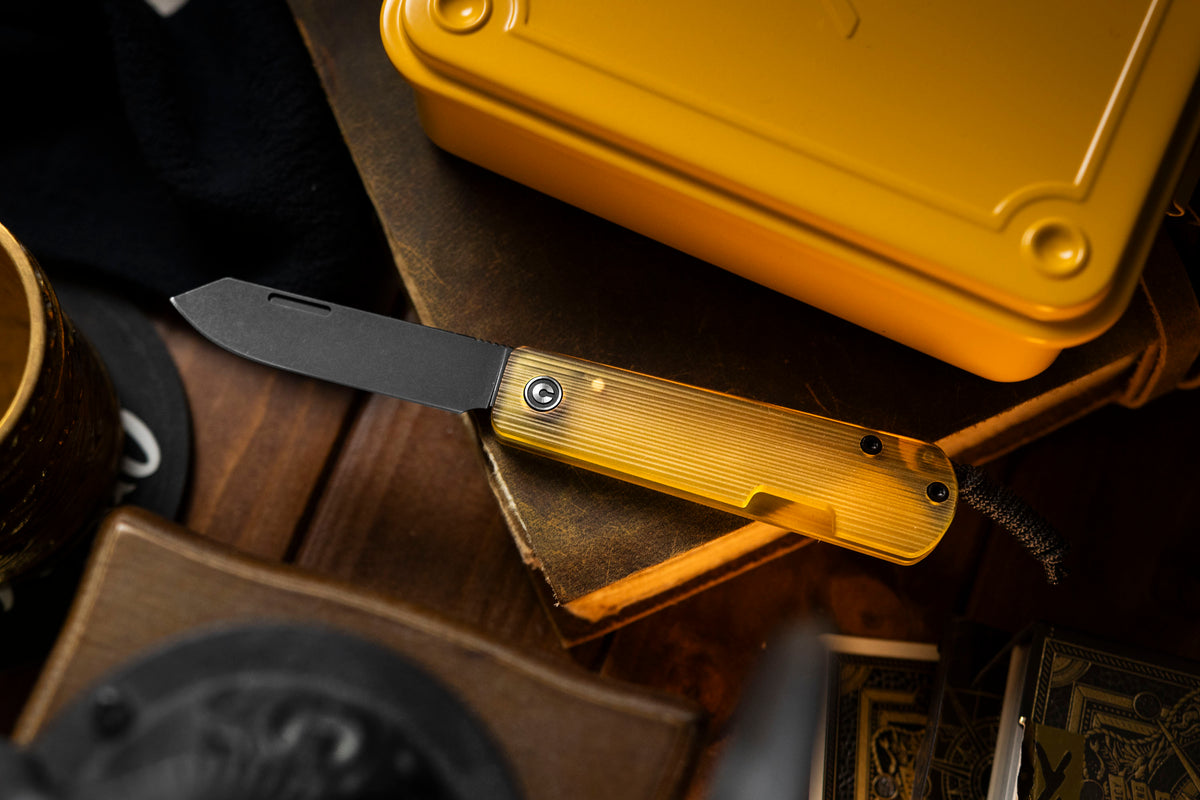 Slippy Sendy pocket knife with tan Ultem handle clipped alongside other EDC gear in pouch