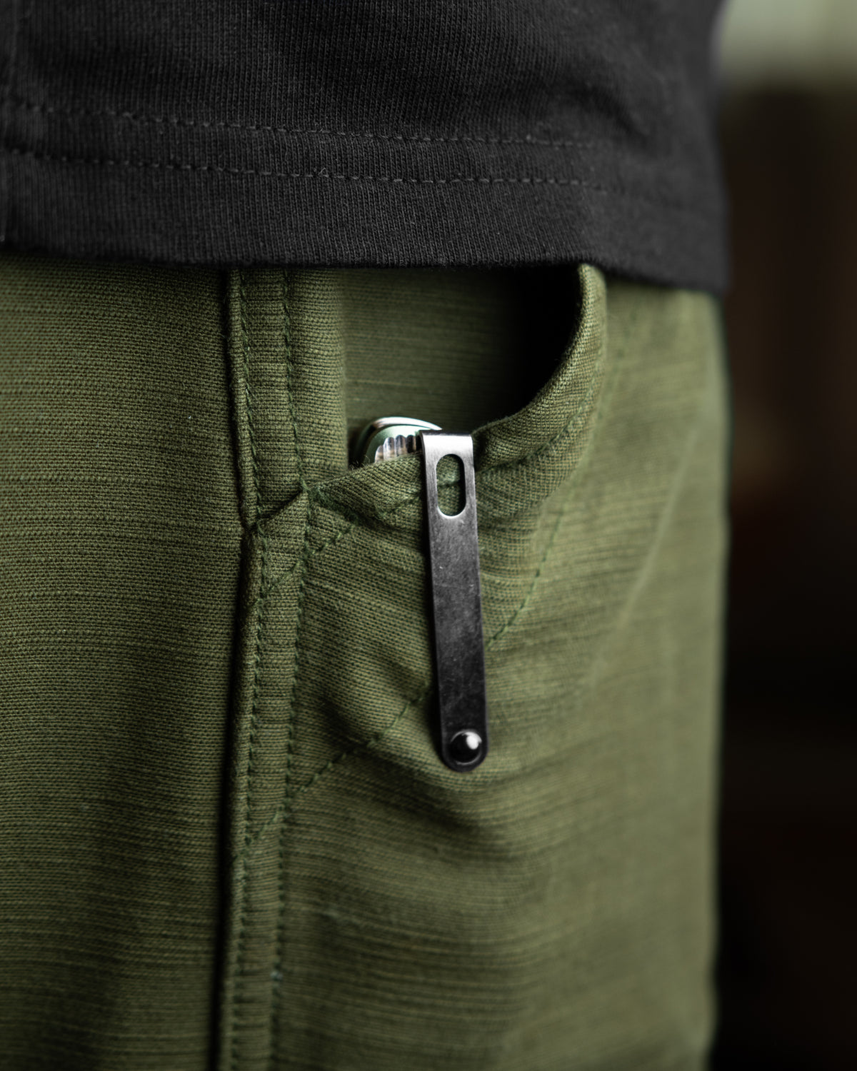 Capcom pocket knife with Mission Control green handle clipped inside pocket
