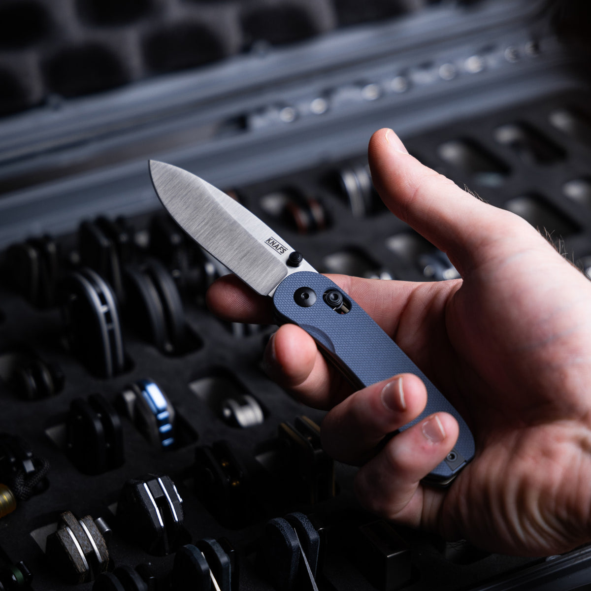 Lander 3 Pocket Knife in Horizon Blue G10 held in hand near a laptop keyboard
