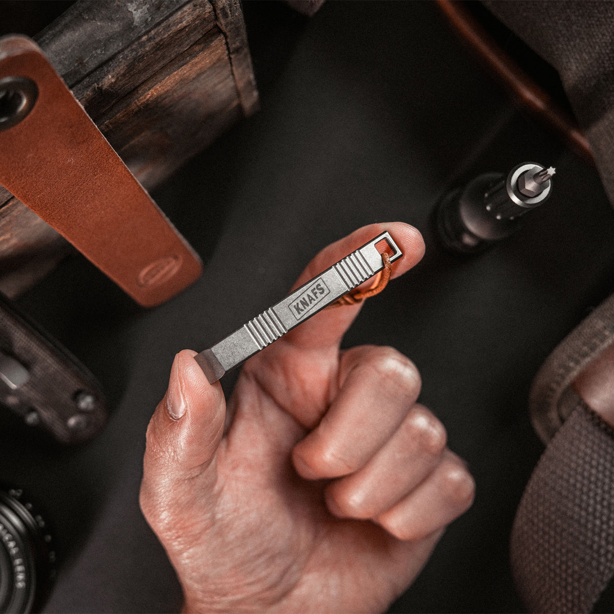 Hand using Sancho pry bar tool to pry open a wooden crate