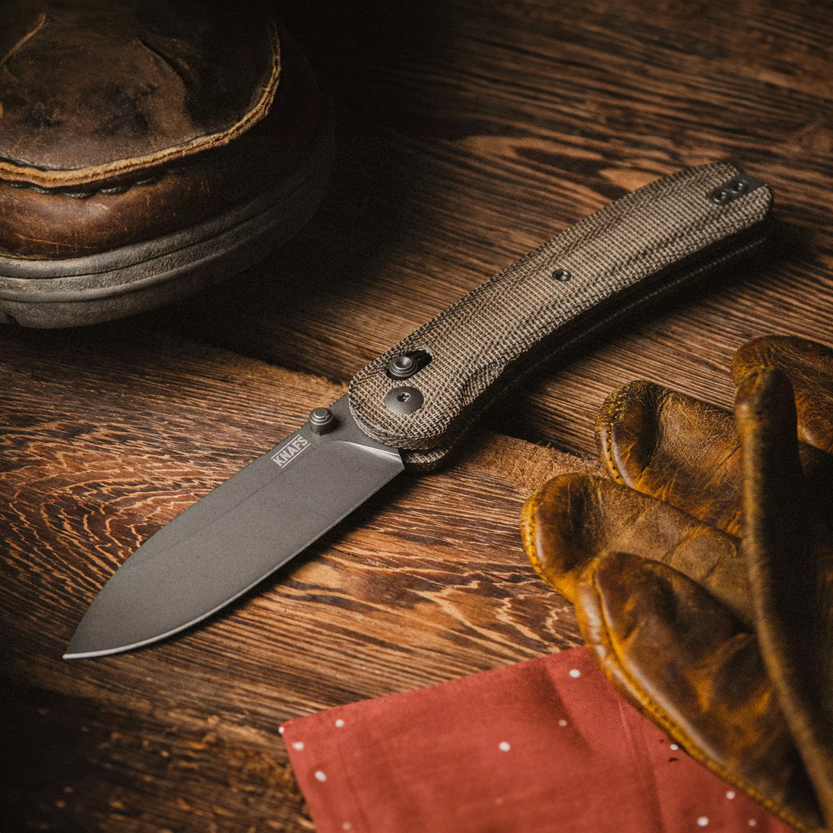 Lander 2 Pocket Knife in Moondust Micarta, open, lying on a wood table with autumn leaves