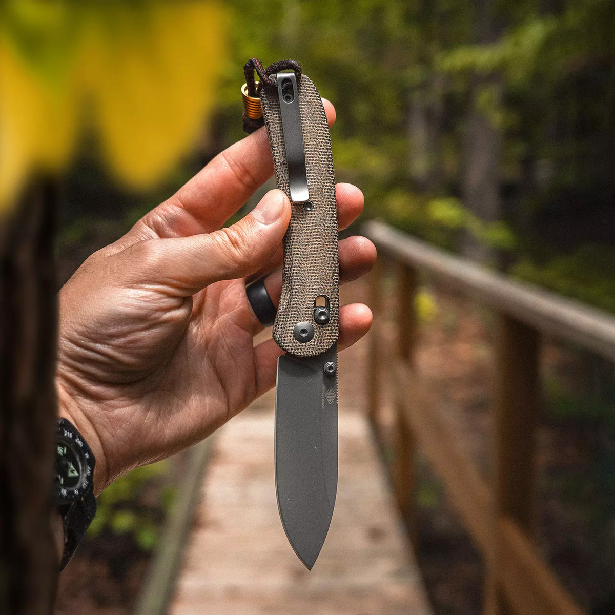 Lander 2 Pocket Knife in Moondust Micarta, open, held upright, close-up with autumn leaves