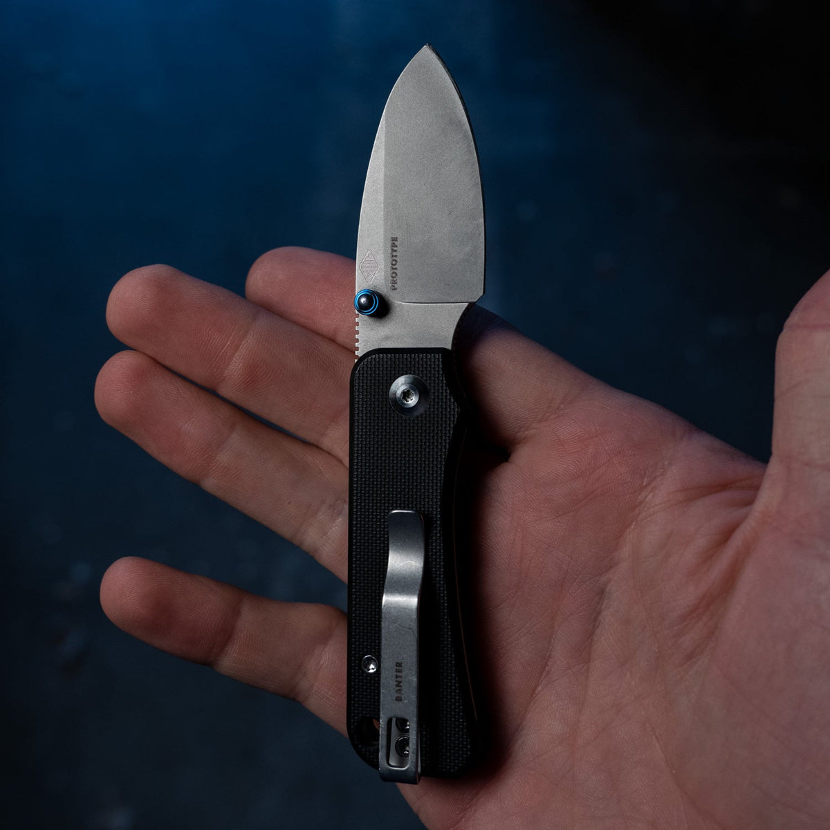 Baby Banter Pocket Knife in Burgundy G10, closed, held in hand, back view