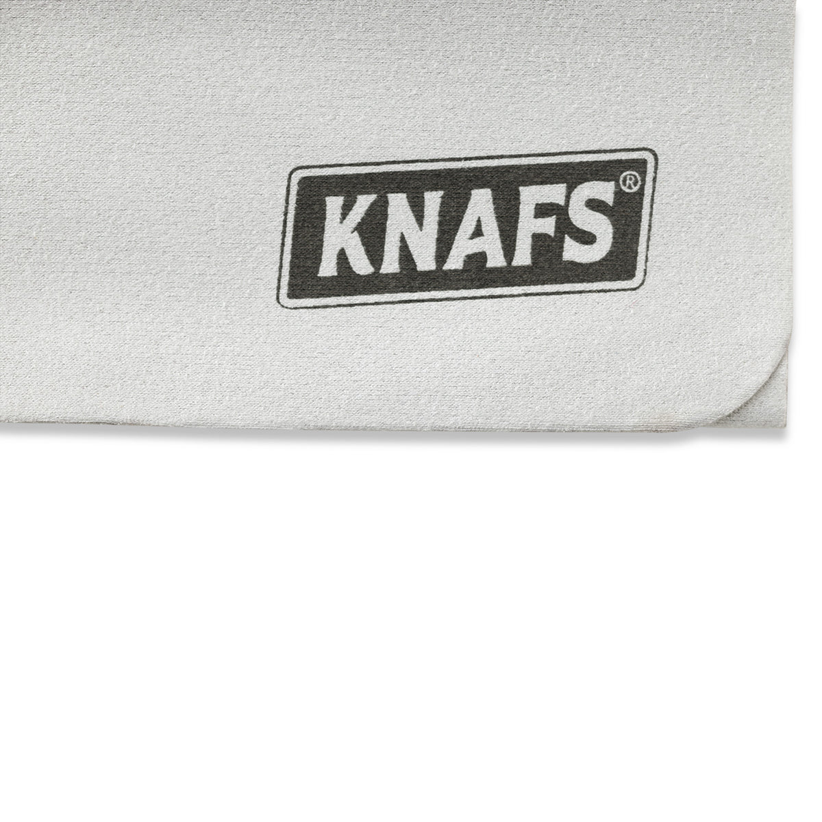Close-up of black Knafs logo embossed on gray suede polishing cloth