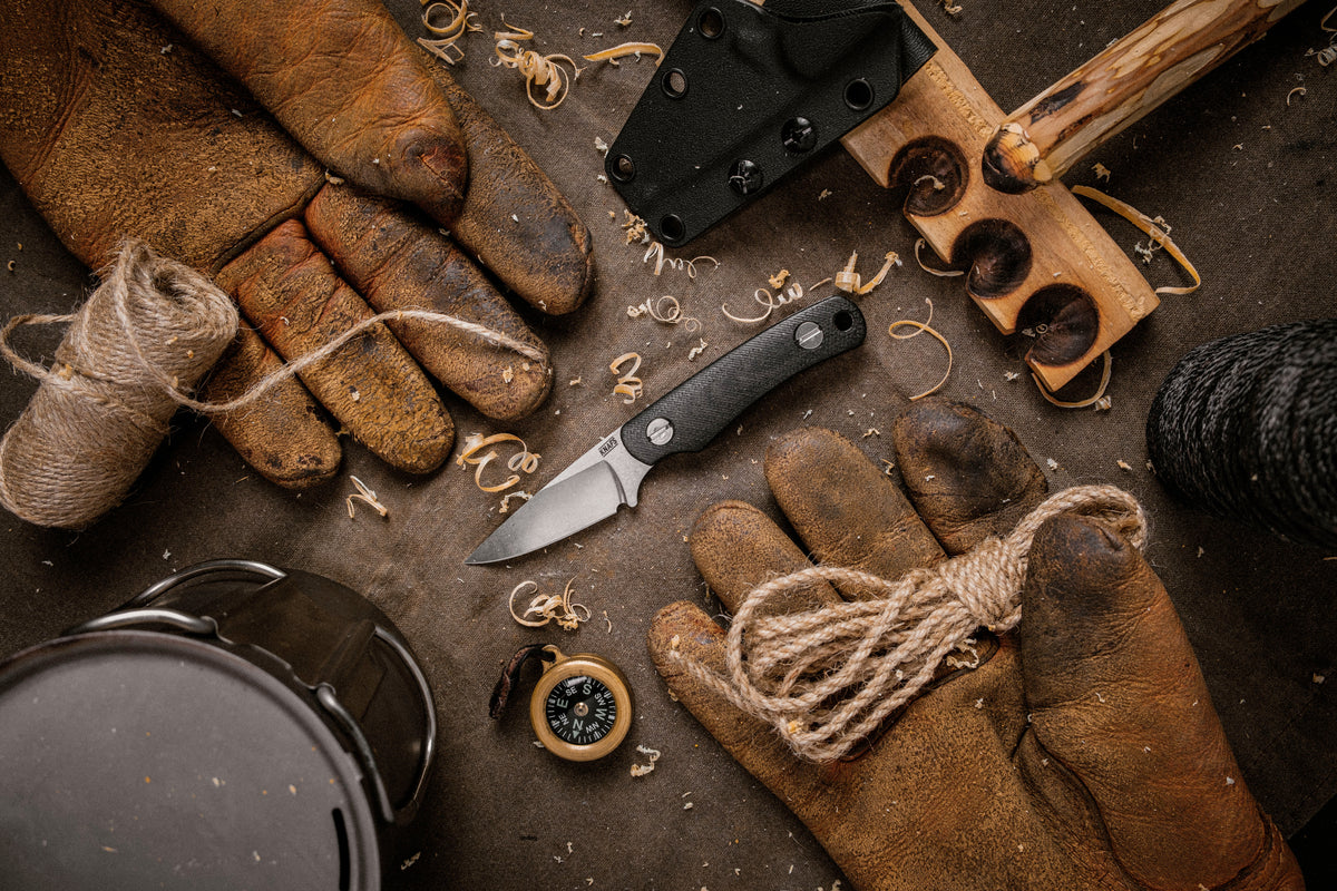 Little Lulu fixed blade knife with black micarta handle flat lay with leather gloves and tools