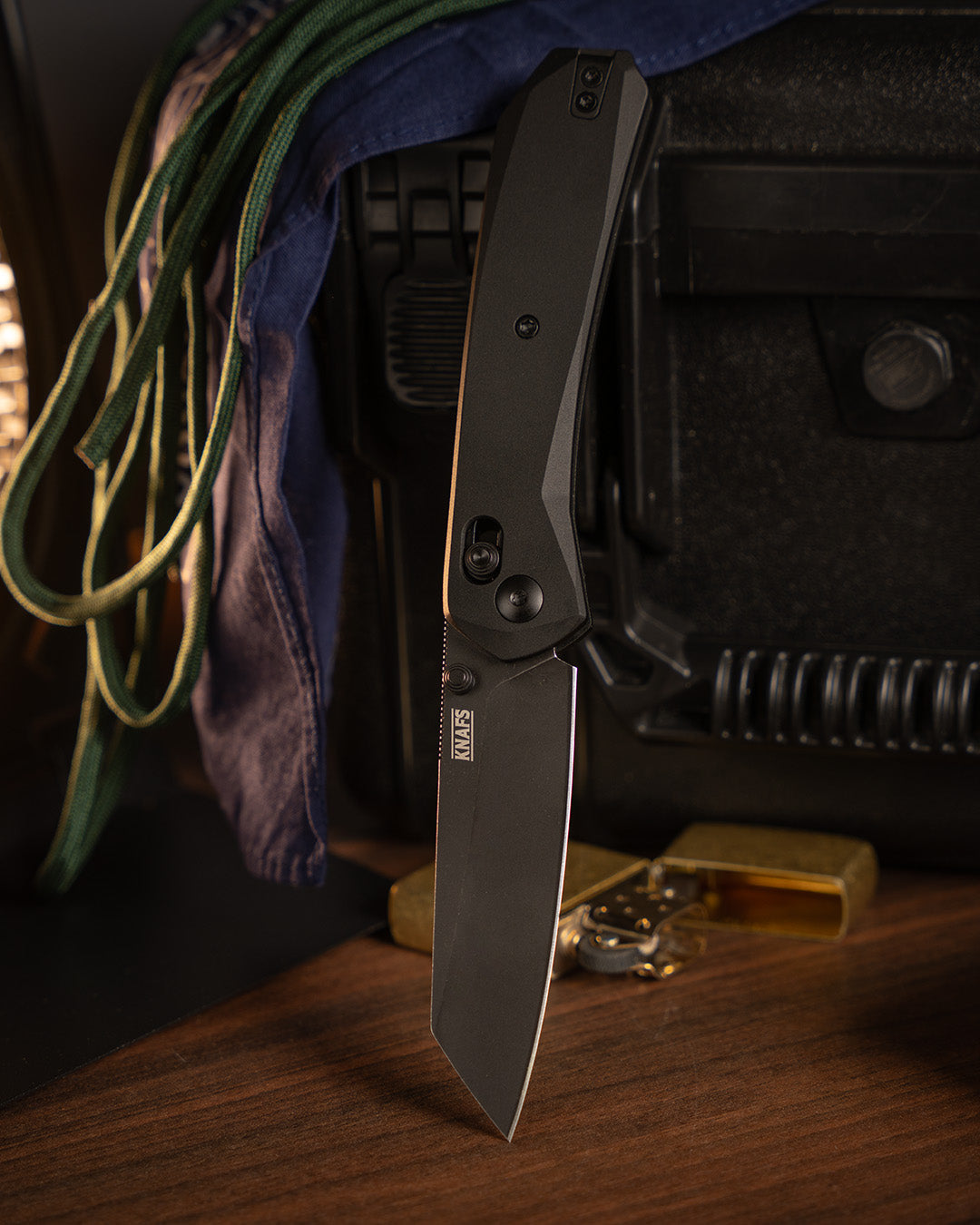 Lander 2 Reverse Tanto pocket knife with black aluminum handle hanging by paracord lanyard