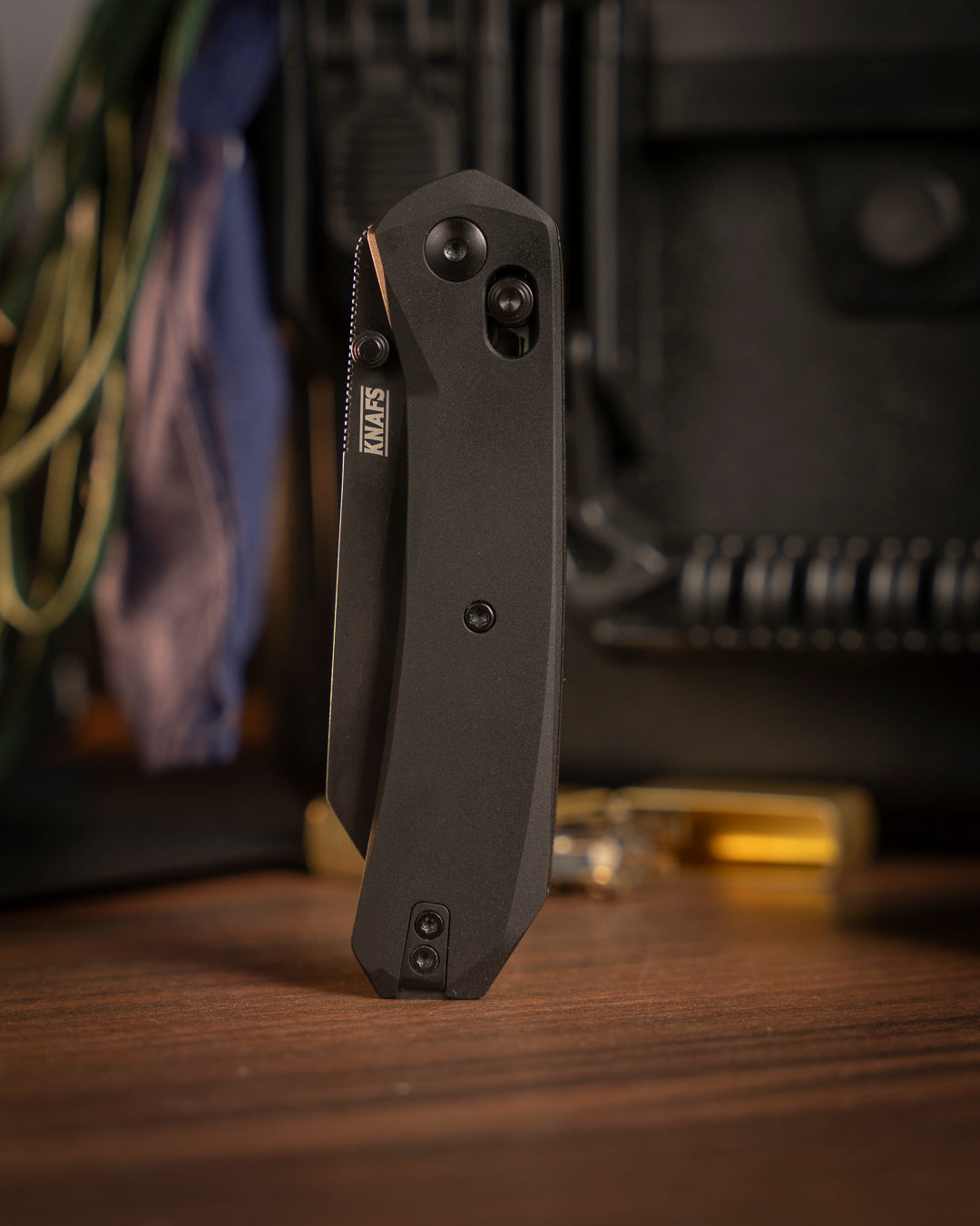 Lander 2 Reverse Tanto pocket knife with black handle on wood surface with warm lighting