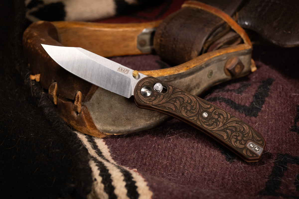 Lander 2 knife, Filigree Western clip point edition, closed, resting on woven blanket