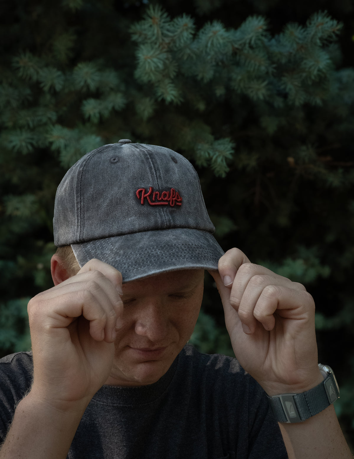 Man wearing black canvas Knafs Dad Hat, close-up portrait