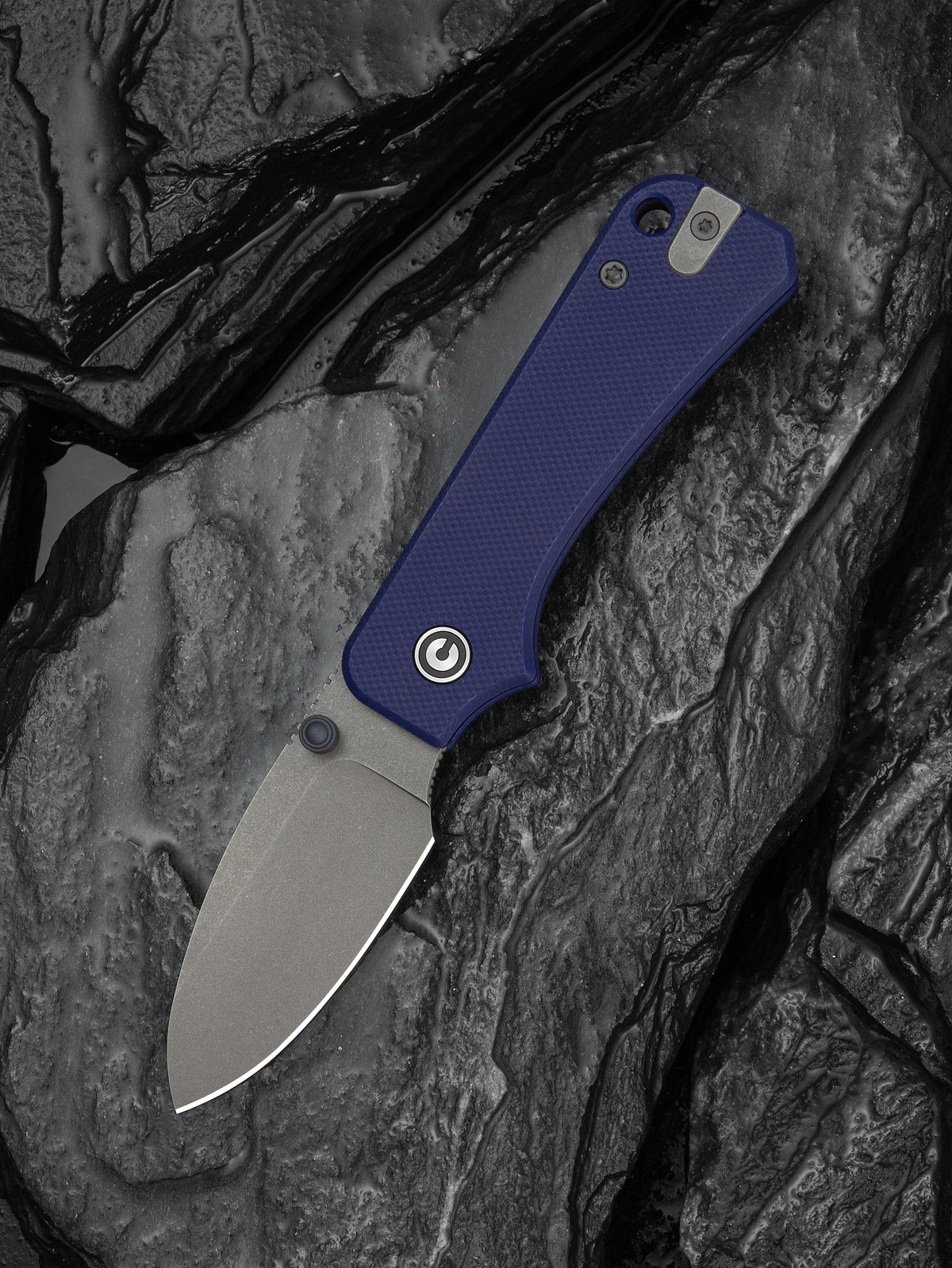 Baby Banter slip joint knife with blue G10 handle, open, resting on dark stone surface