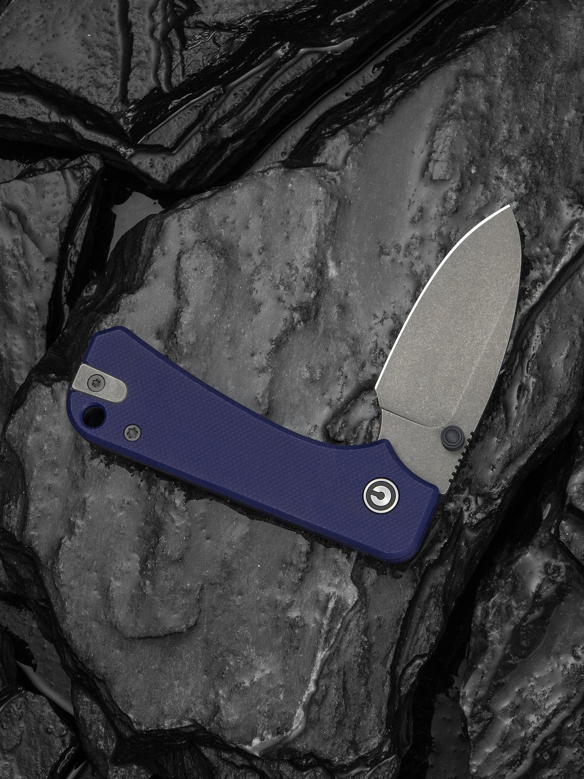 Baby Banter slip joint knife with blue G10 handle resting on dark stone surface