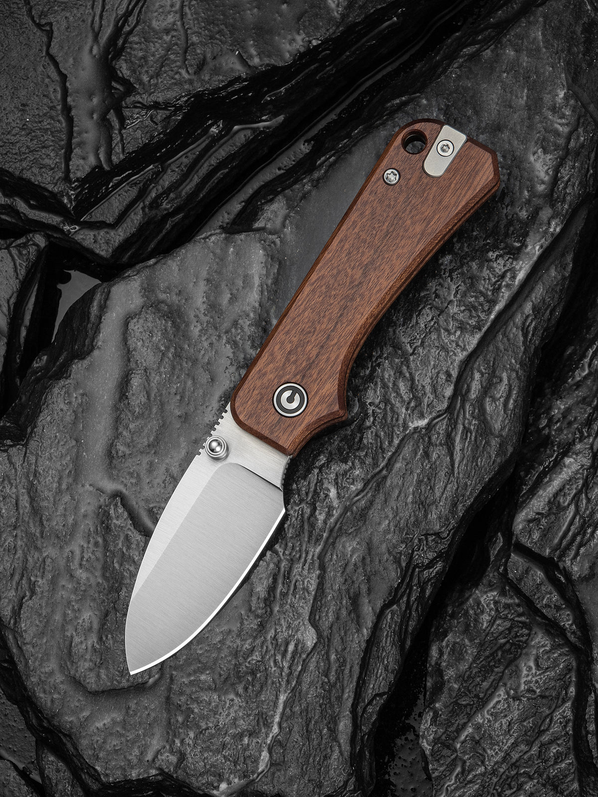 Baby Banter slip joint knife with brown wood handle resting on dark stone surface