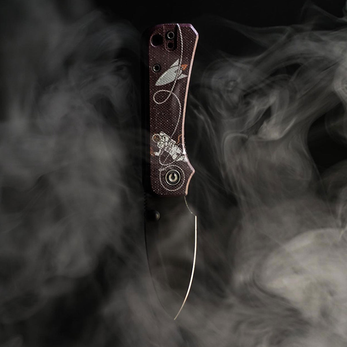 Jupiter Space Kitty Baby Banter Scales knife shown against a smoky cloud background