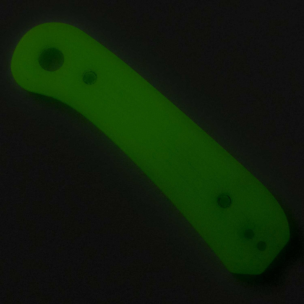 Lander 1 Knife Scales in Kirinite Glow photographed in the dark, showing the bright green glow-in-the-dark effect