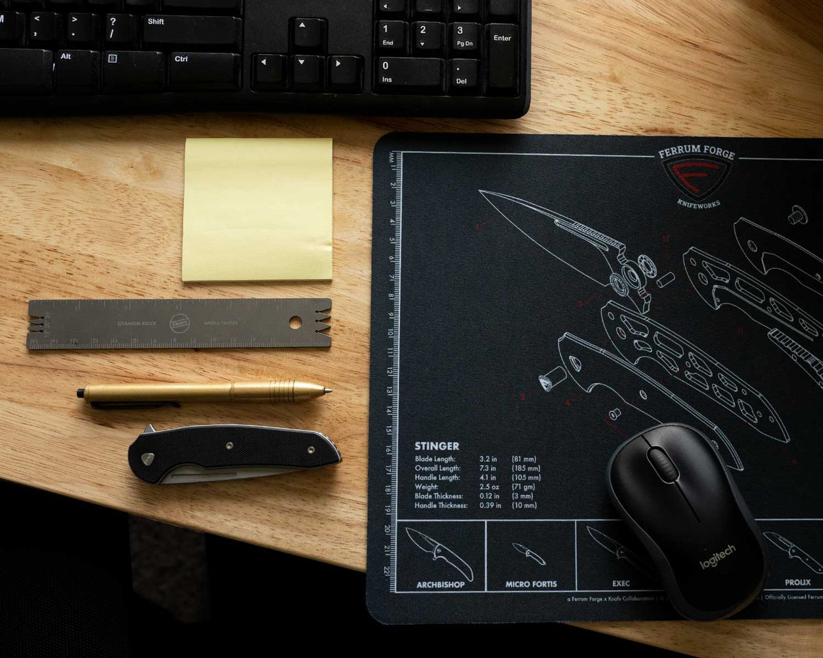 Knafs x Ferrum Forge Stinger Knife Shop Mat on a home office desk with pens and the knife