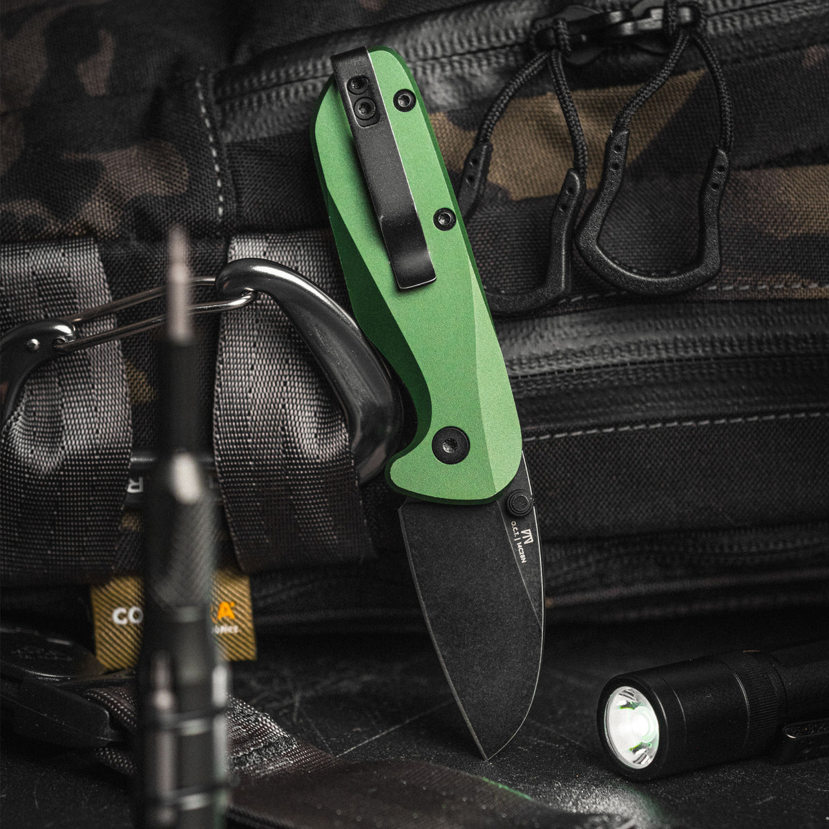 O.C.T. pocket knife with O.D. green handle clipped to truck engine bay compartment