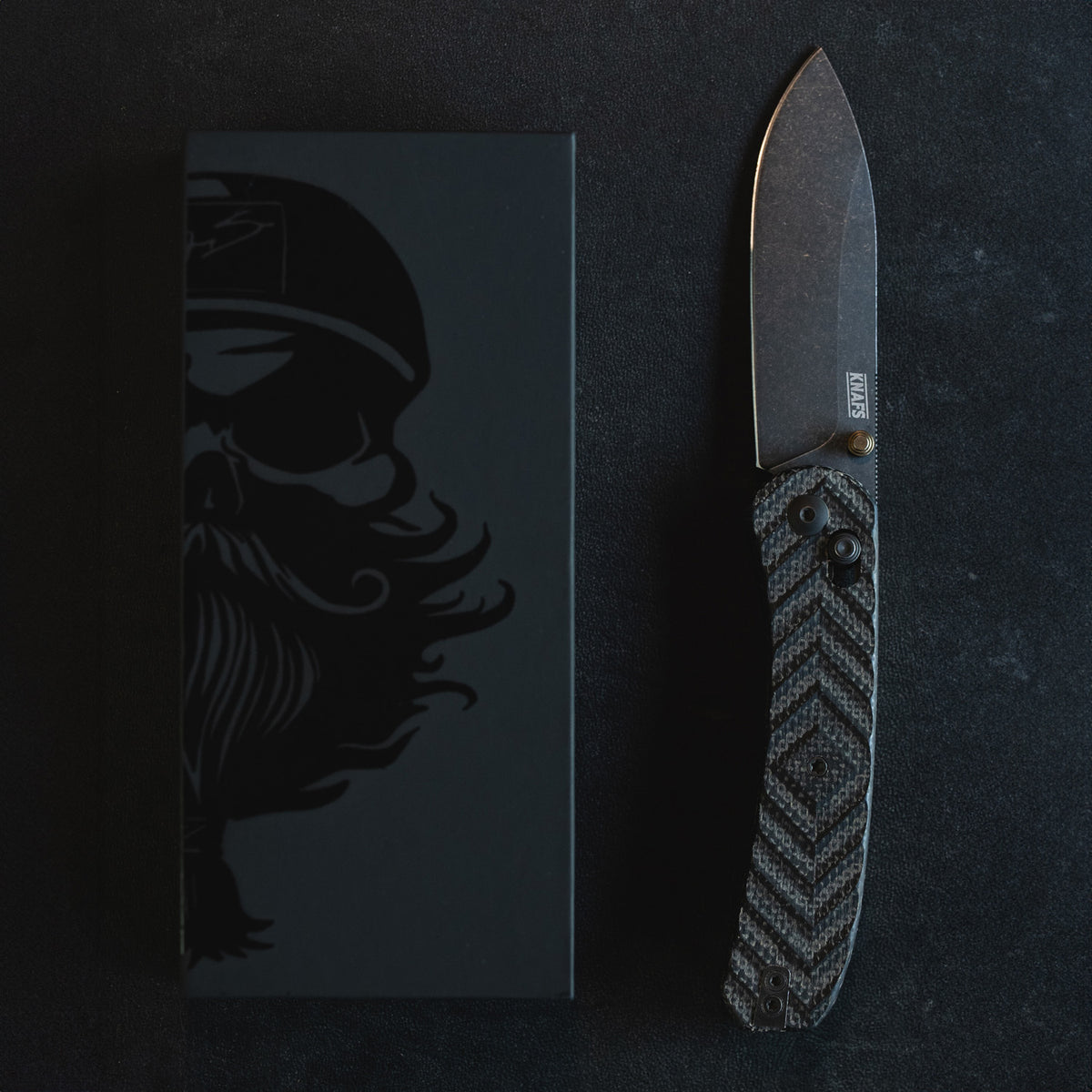 Jeremy Siers Lander 2 knife closed, resting on branded box with skull artwork