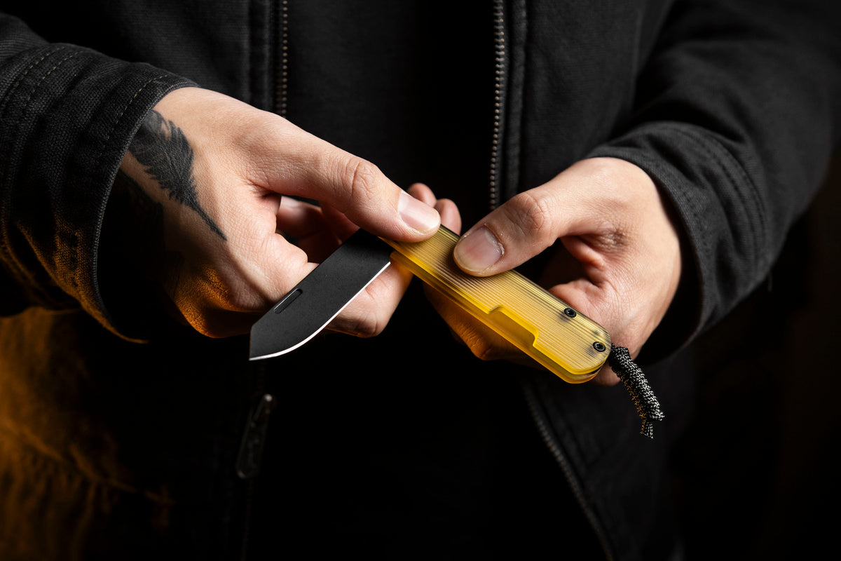 Close-up of hand holding Slippy Sendy pocket knife with tan Ultem handle