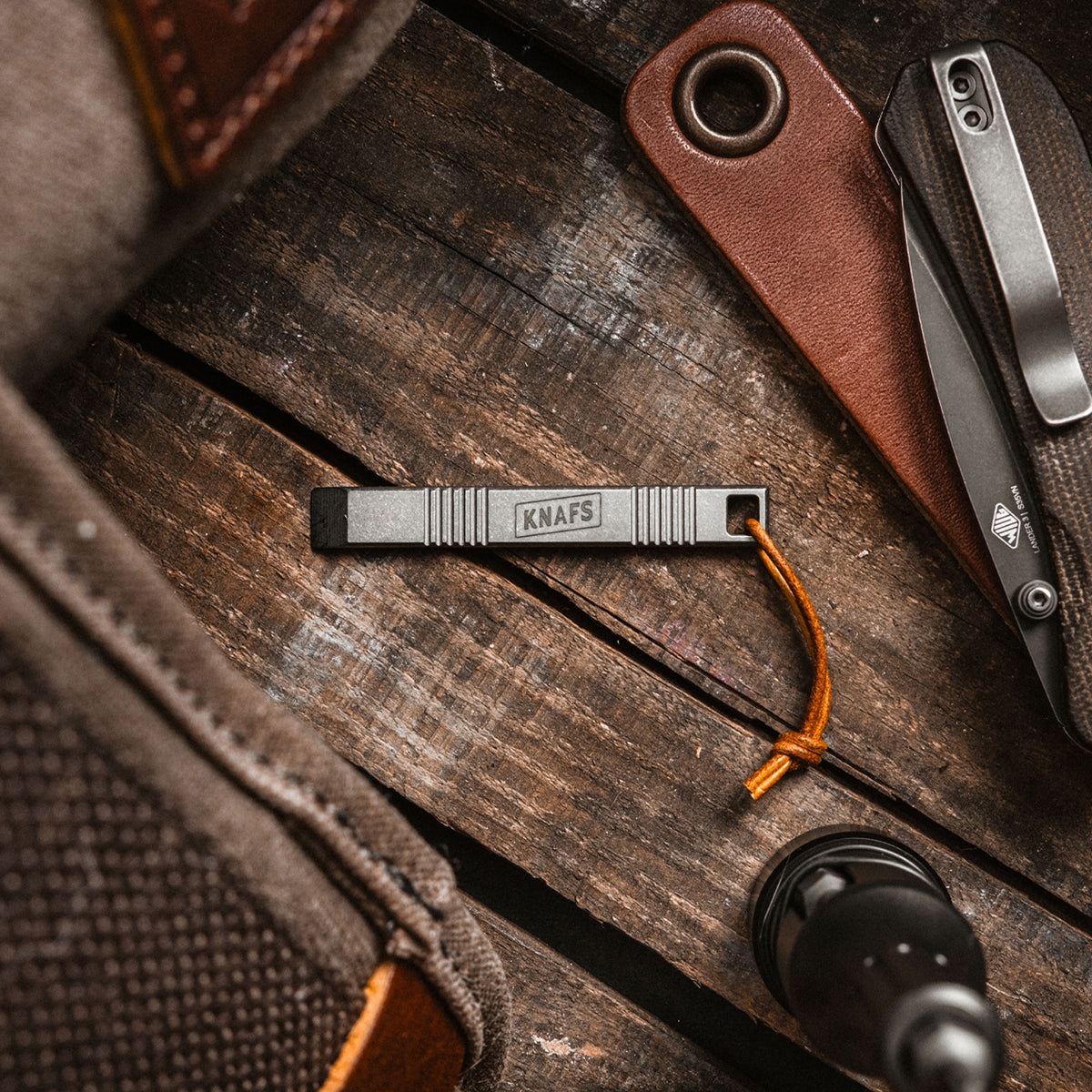 Sancho pry bar tool laid on leather EDC pouch with knife and other gear
