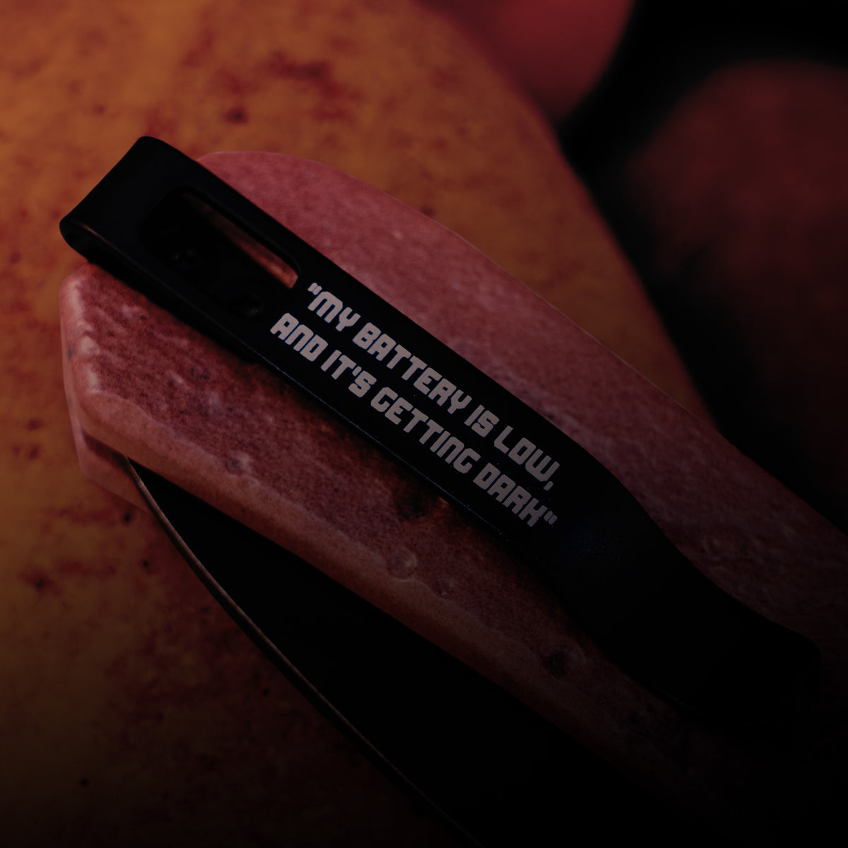 Lander 1 Pocket Knife 21st Anniversary Edition dramatic packaging shot with the knife handle emerging from dark wrapping