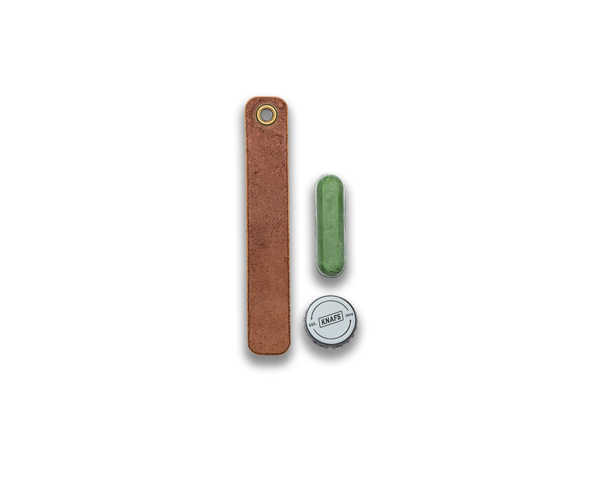 Leather Honing Strop for Pocket Knives, a rolled tan leather strop shown with a small stropping compound bottle cap