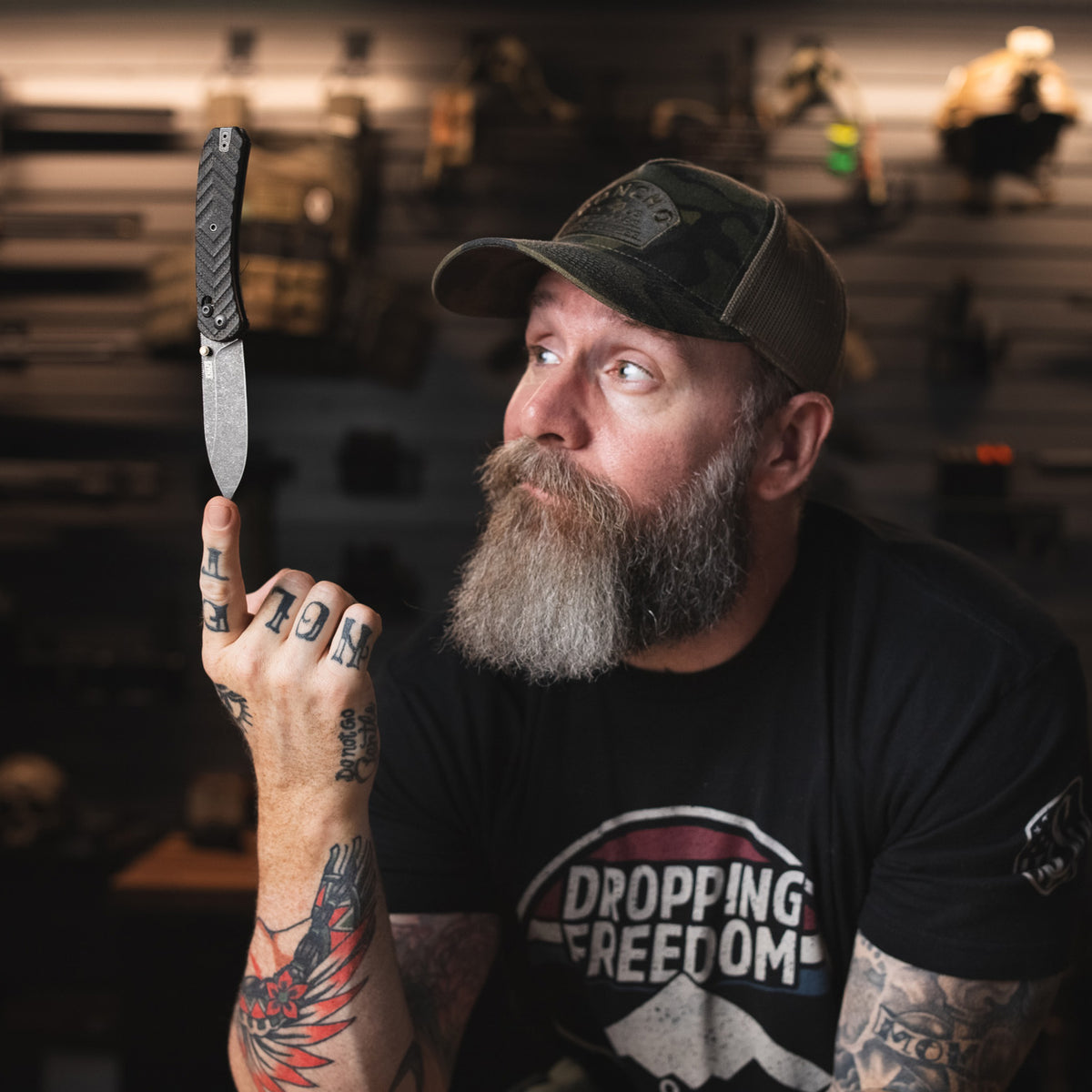 Jeremy Siers Lander 2 knife with black micarta handle, open, standing upright on dark background