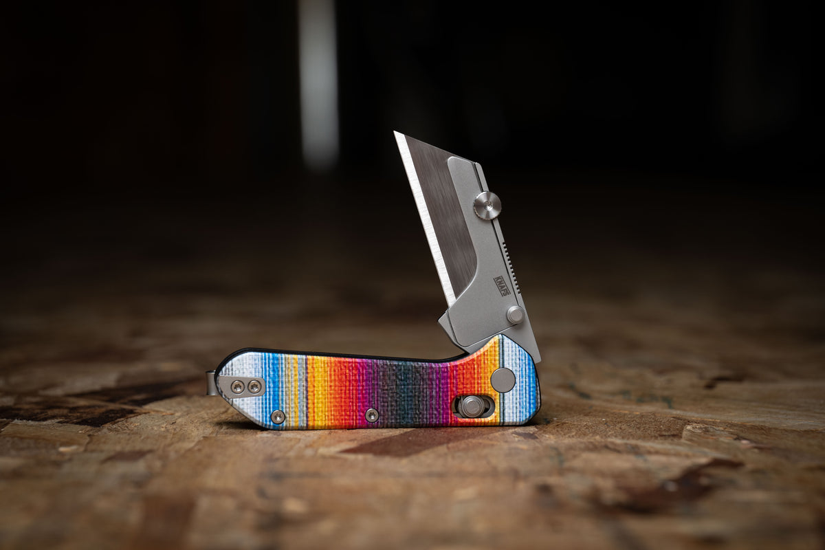 Yuti utility knife with UV printed Mexican blanket pattern handle standing upright outdoors