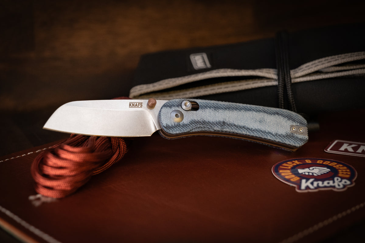 Lander 3 sheepsfoot pocket knife, open, resting on leather surface