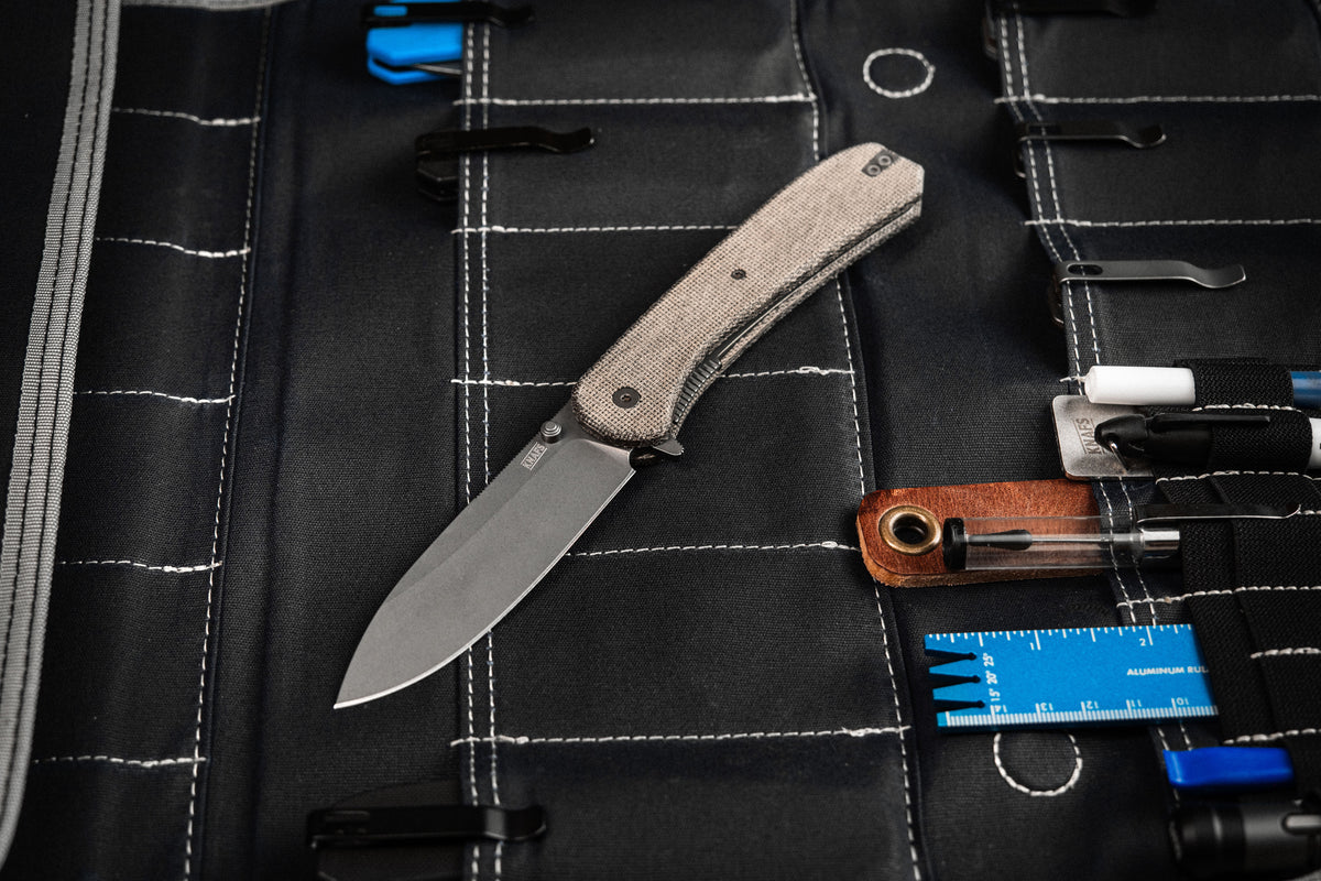 Lander 7 pocket knife with Moondust micarta handle laid out with wallet and EDC gear