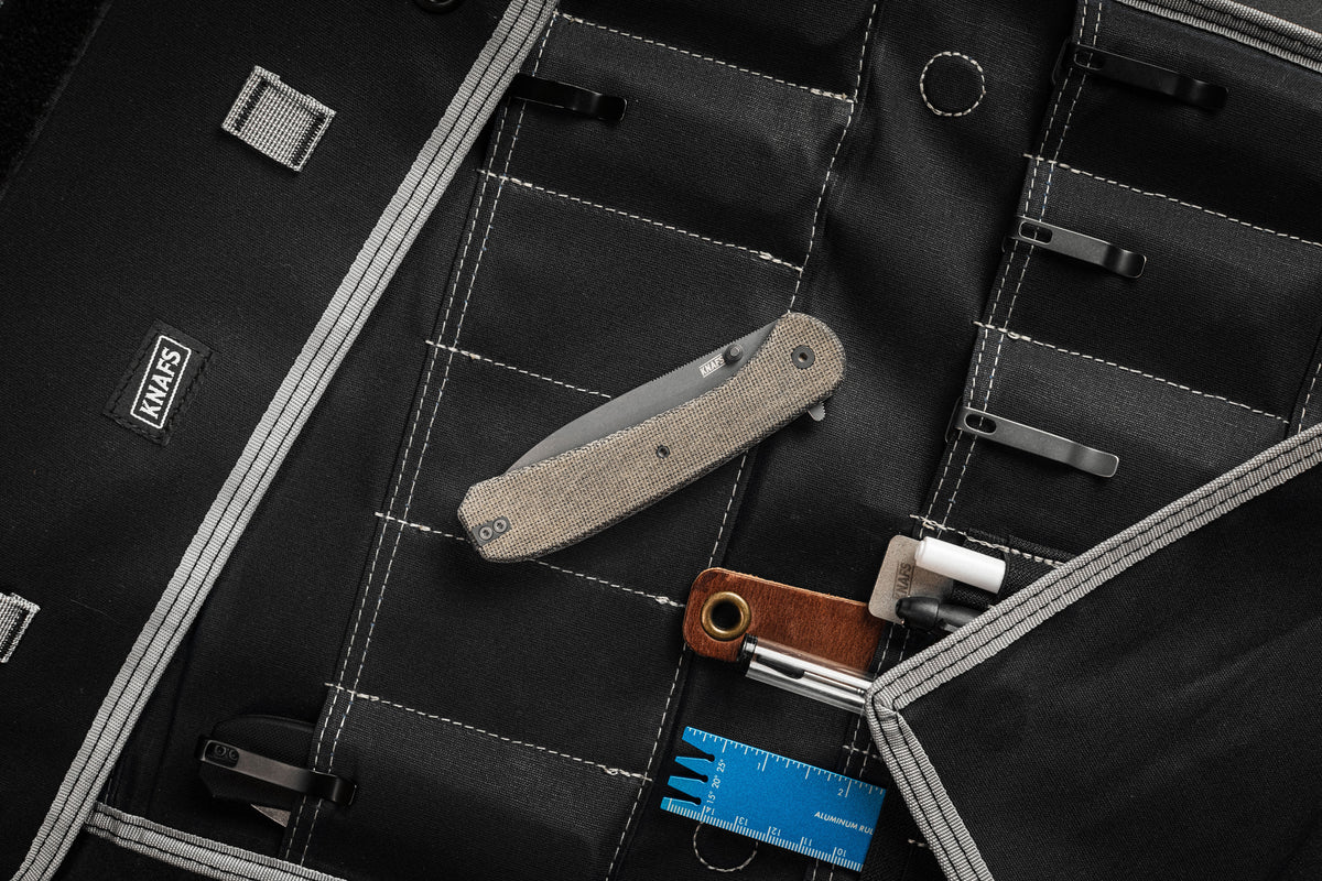 Knafs Lander 7 pocket knife open, showing tan Micarta handle scales, on a black measuring/cutting mat