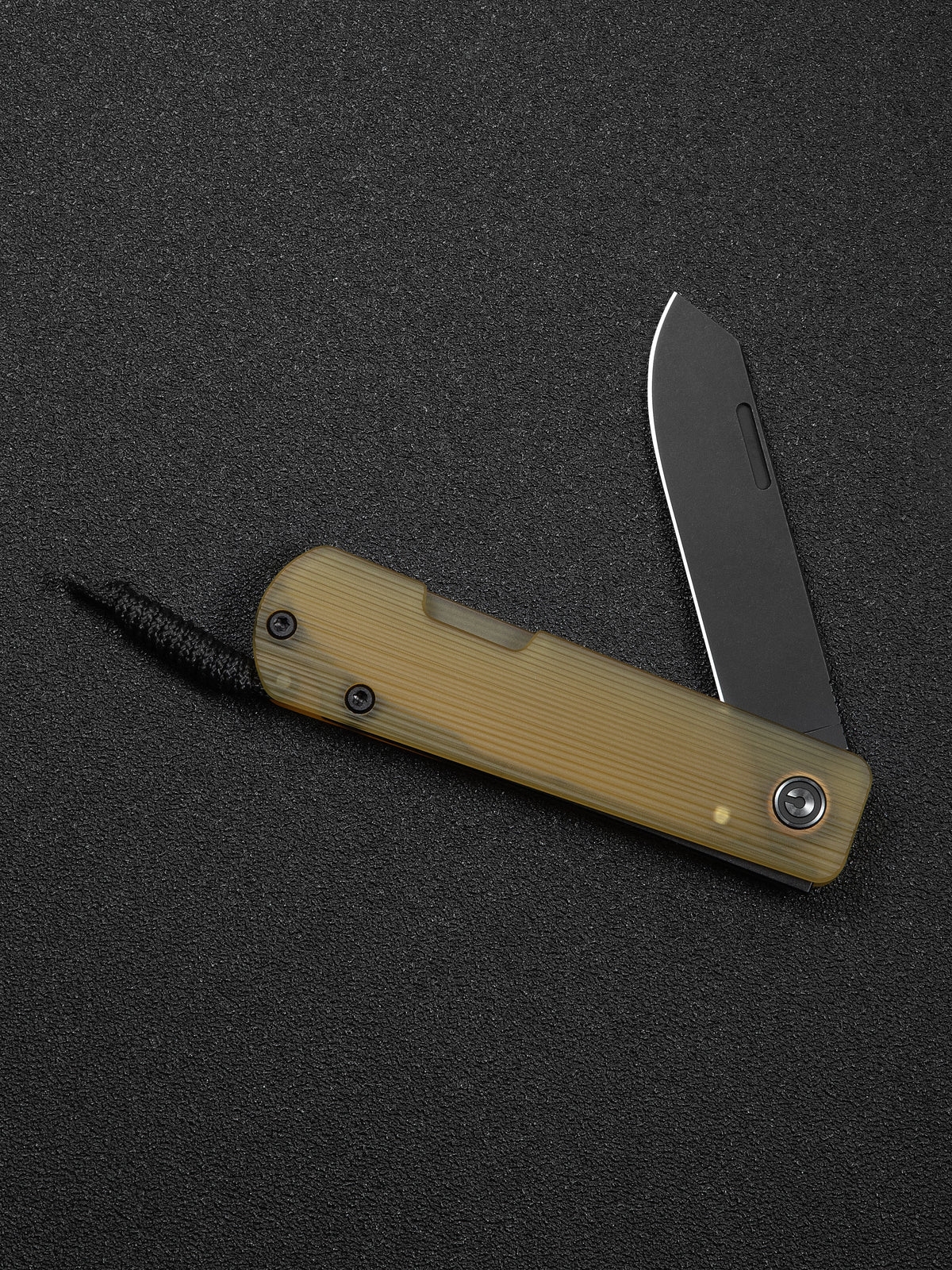 Slippy Sendy pocket knife with tan Ultem handle, closed, on wood surface