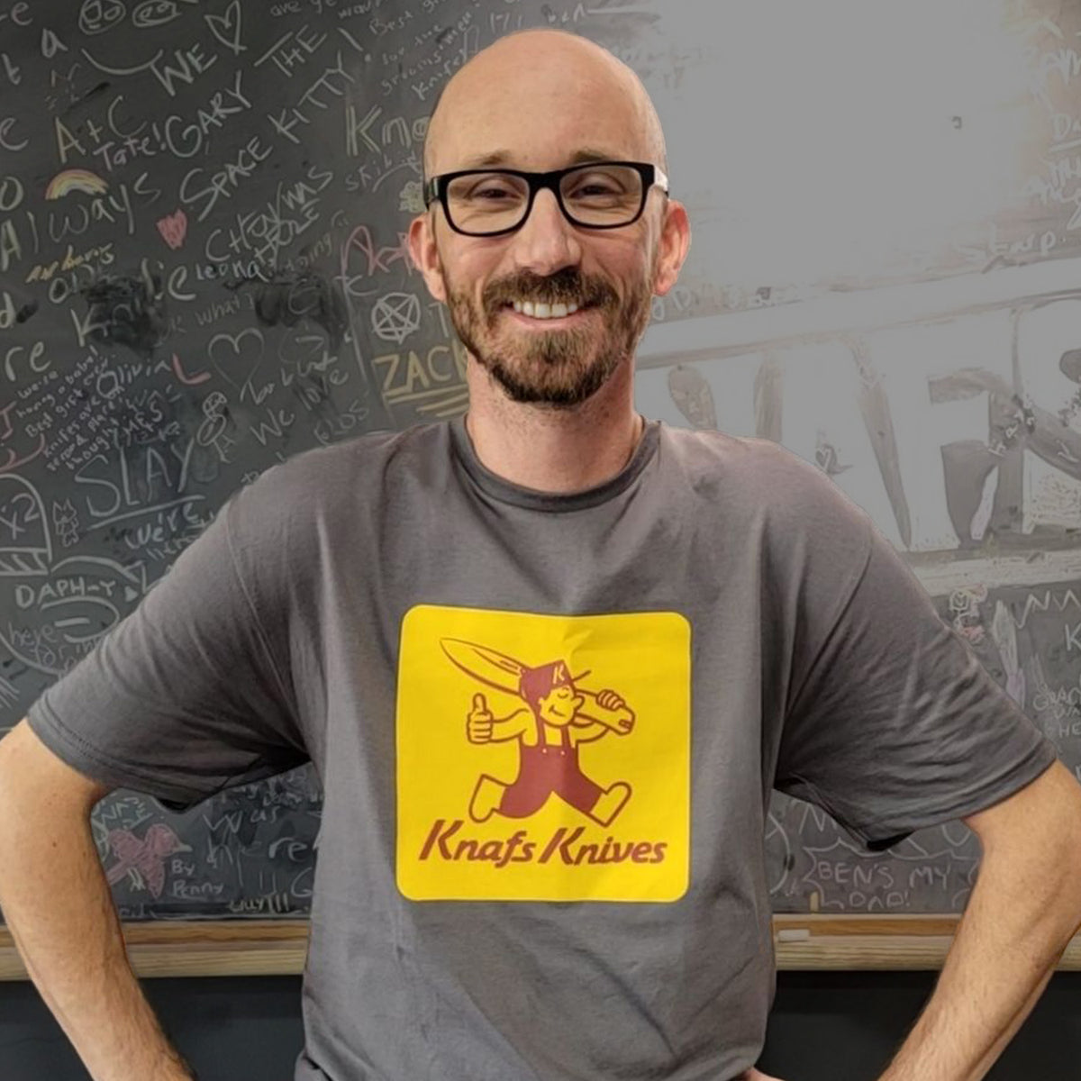 Man standing outdoors wearing Knafs Blade Show West 2025 t-shirt with orange graphic