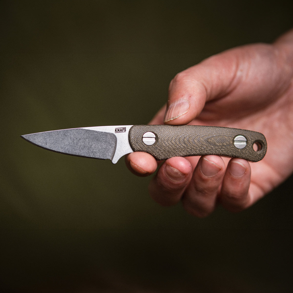 Close-up of hand gripping Little Lulu stonewashed fixed blade knife handle