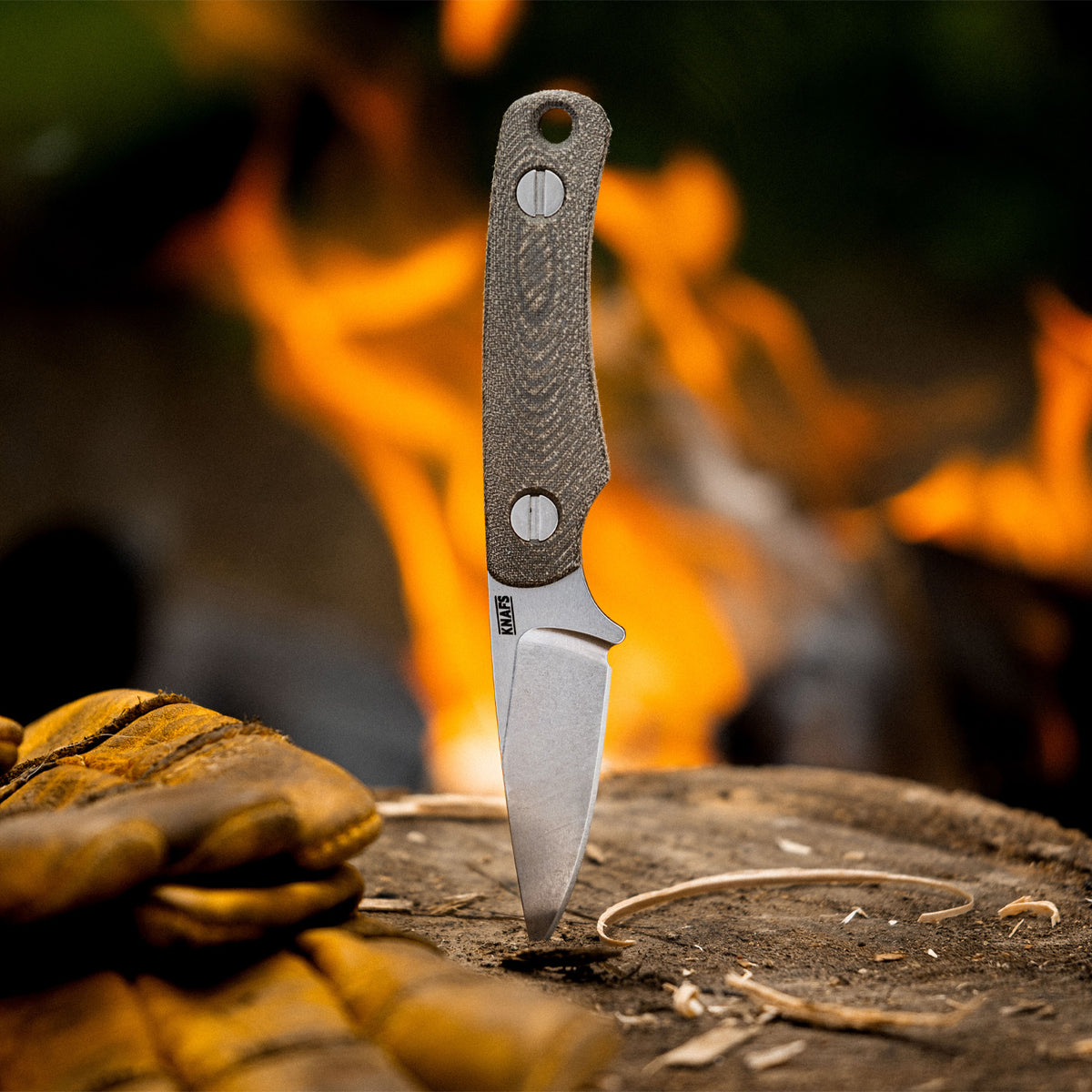 Little Lulu stonewashed fixed blade knife with blade tip embedded in a log
