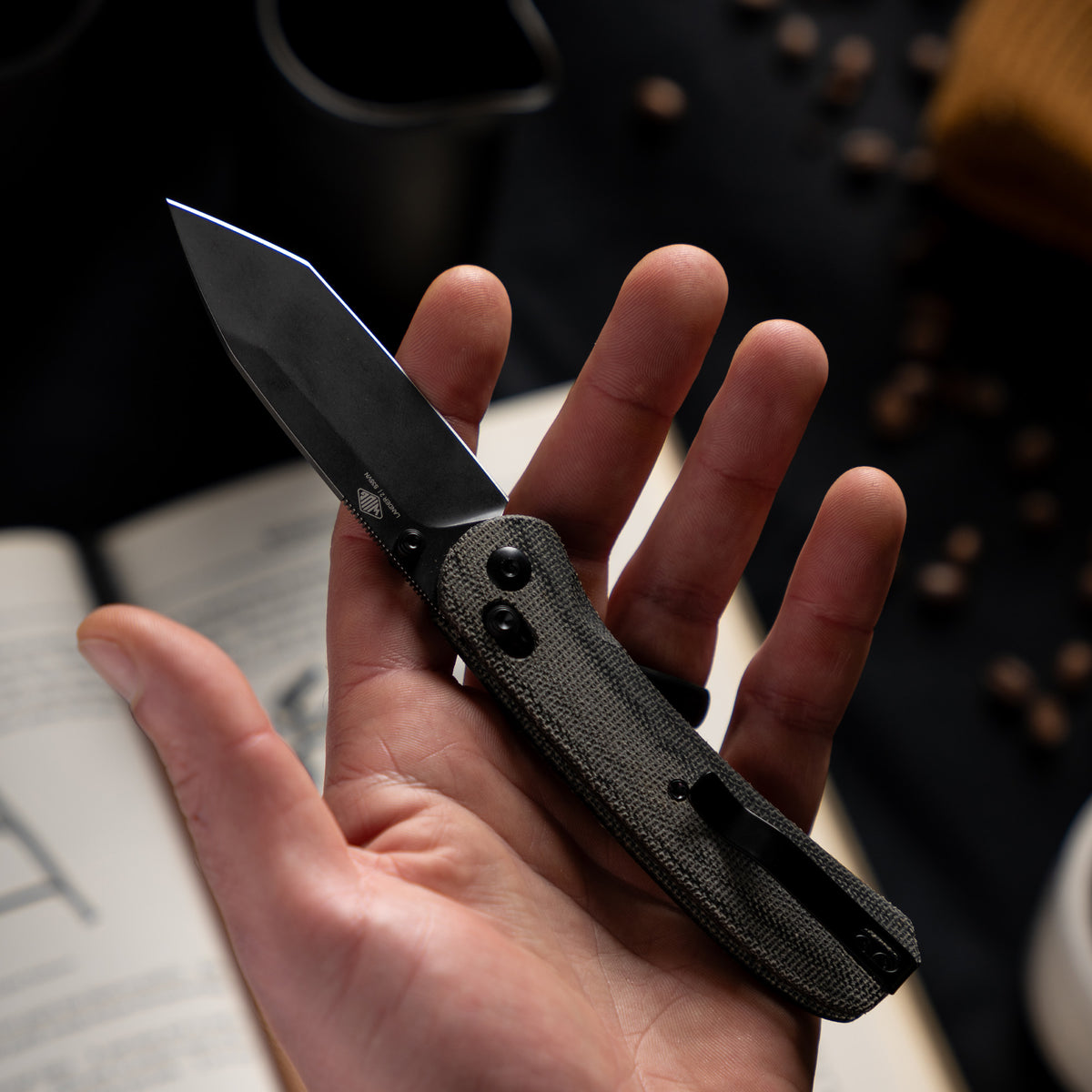 Lander 2 pocket knife with charcoal micarta handle held in hand, back view