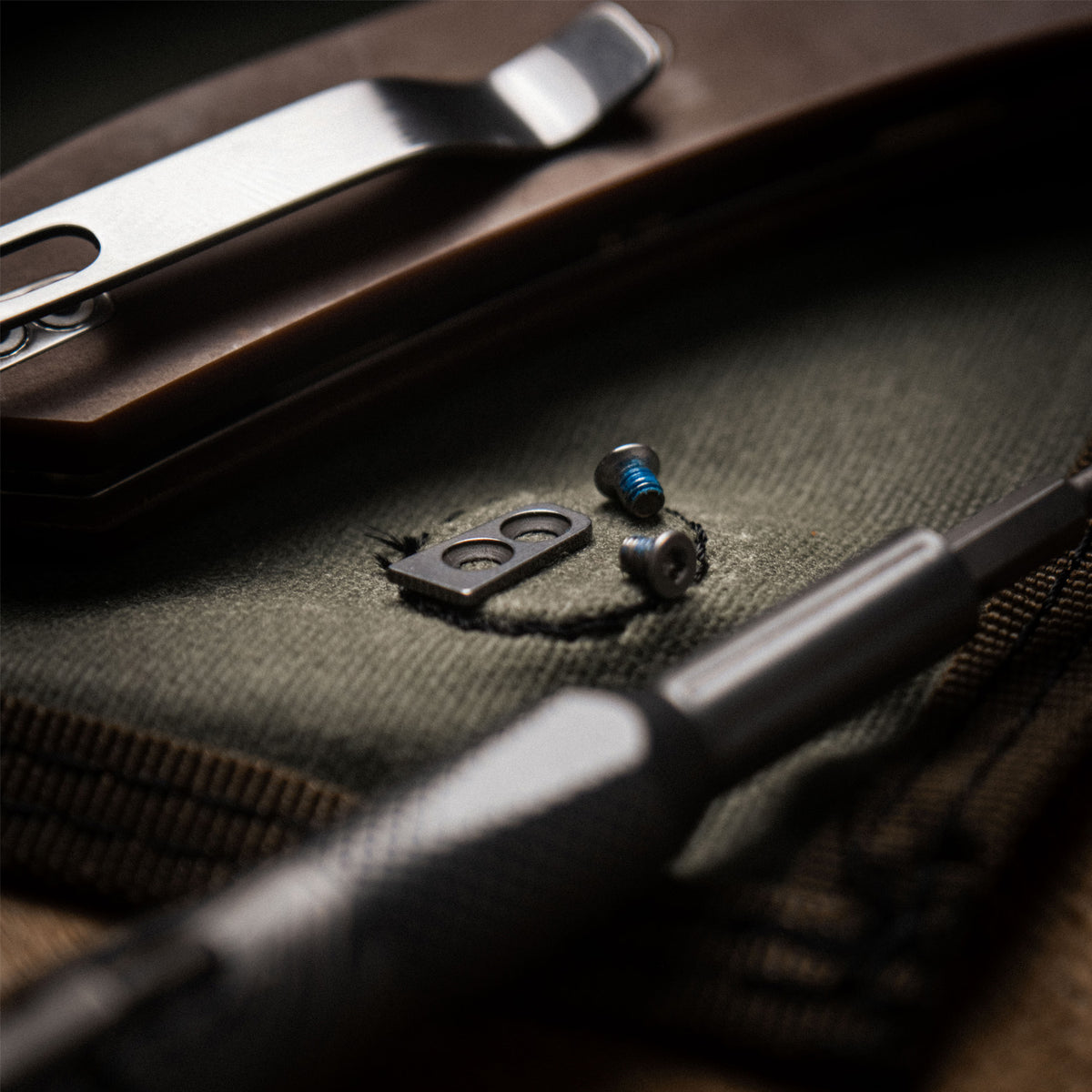Close-up of black EDC knife pocket clip on fabric knife roll