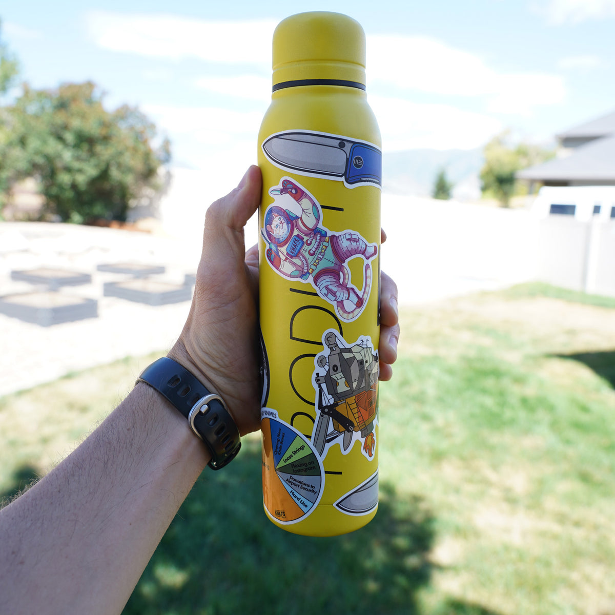 Knafs sticker pack held next to a water bottle outdoors