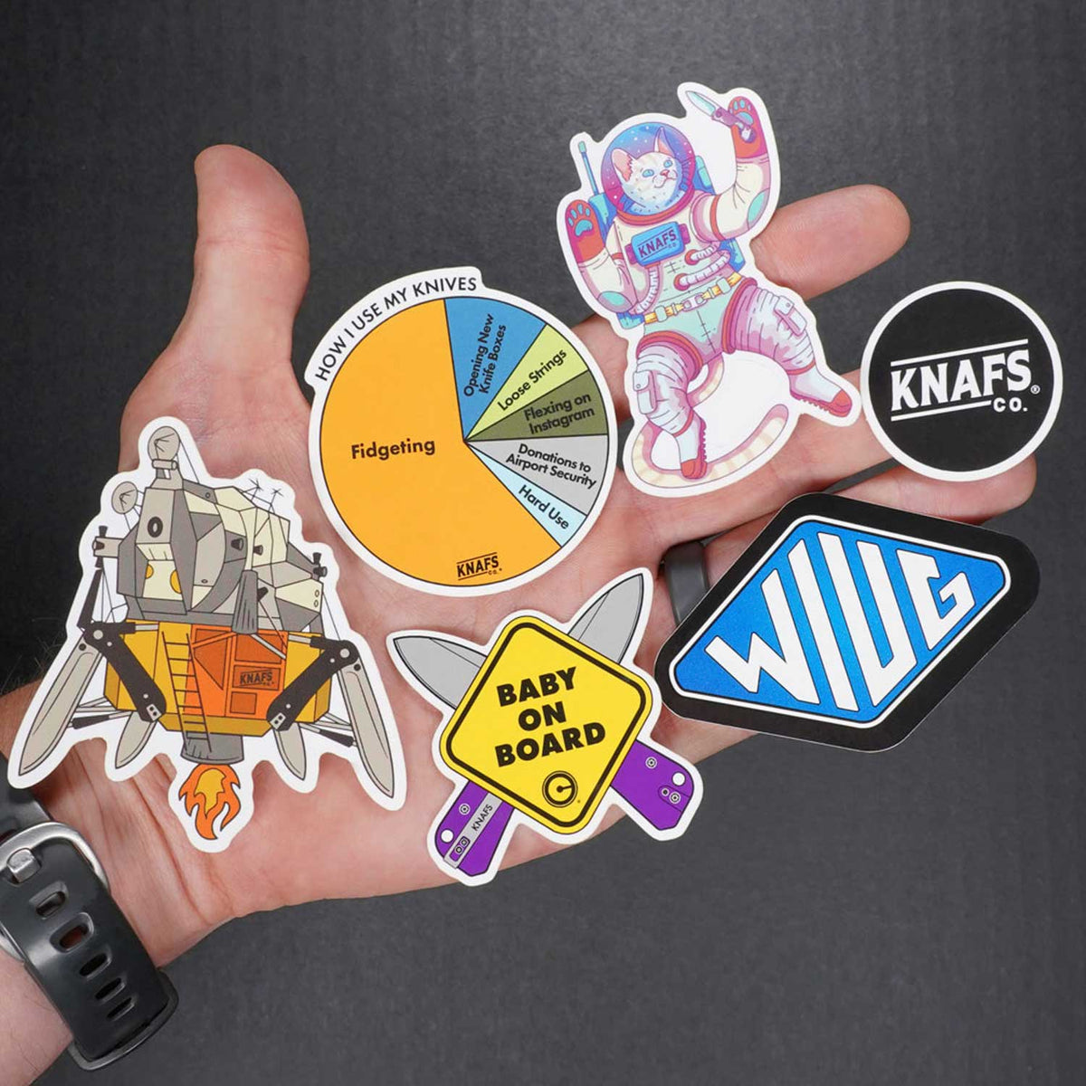 Knafs Sticker Pack - 6 Slaps held fanned out in a hand