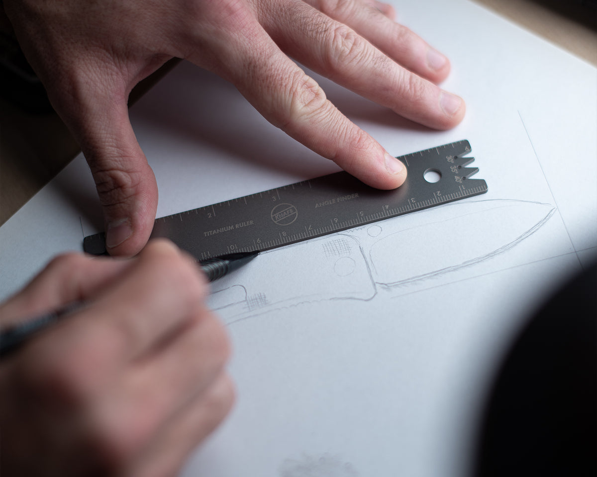 Titanium Ruler + Knife Angle Finder being used to draw a straight line on paper