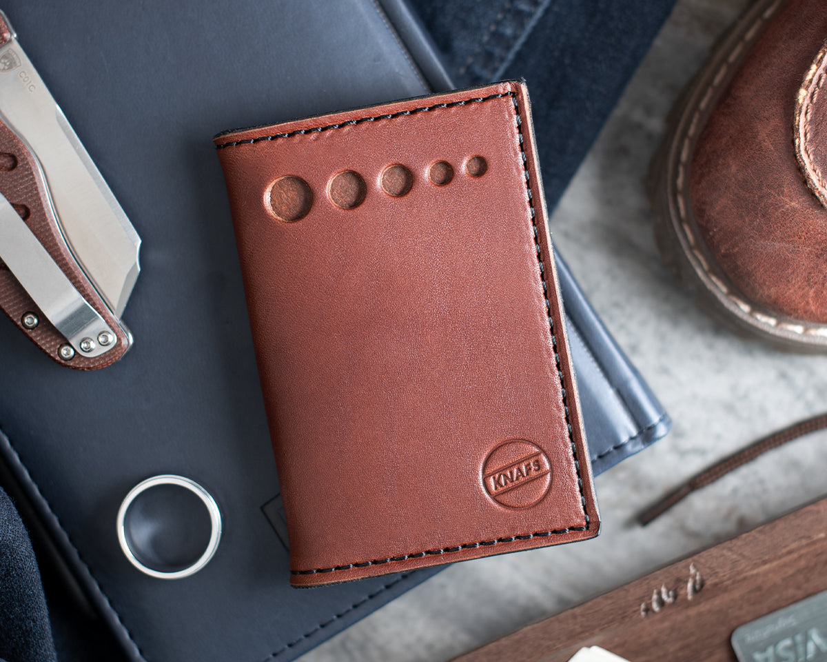 Leather Strop Wallet for Pocket Knives in tan leather shown in an EDC pocket dump with a folding knife, coins, and other everyday carry items